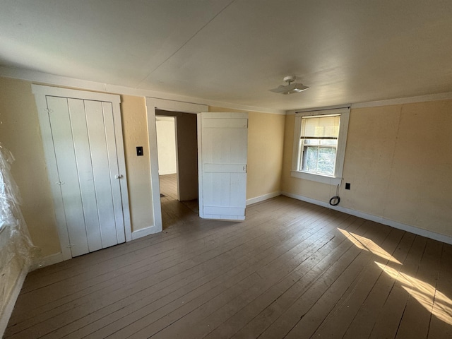 unfurnished bedroom with baseboards and wood-type flooring