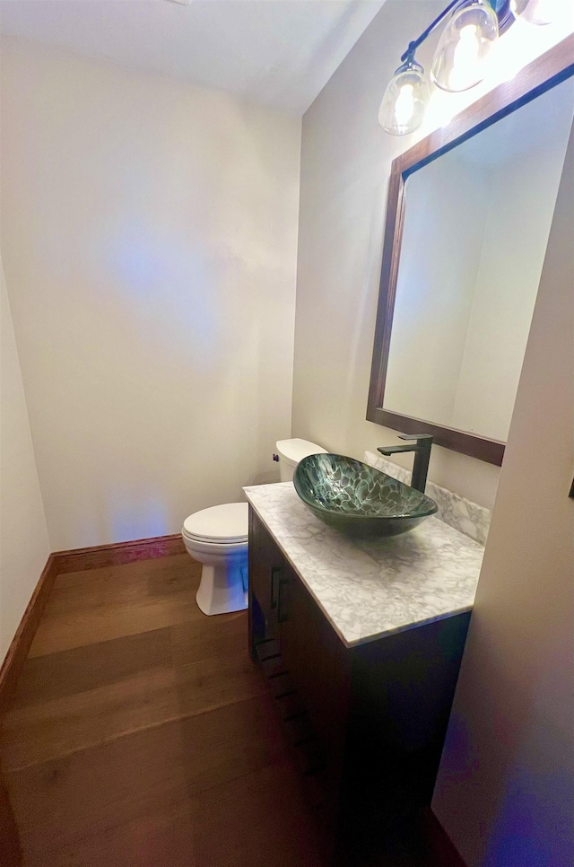 bathroom featuring vanity, hardwood / wood-style floors, and toilet