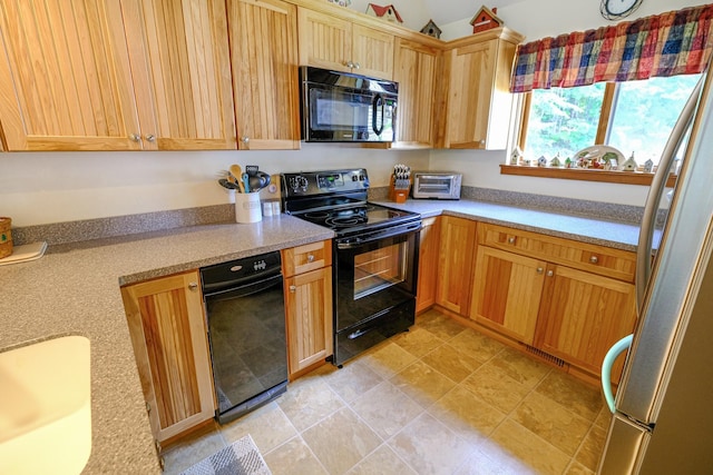 kitchen with a sink, black appliances, light countertops, and a toaster