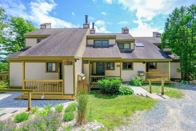 view of front of home featuring a shingled roof, a chimney, and a porch