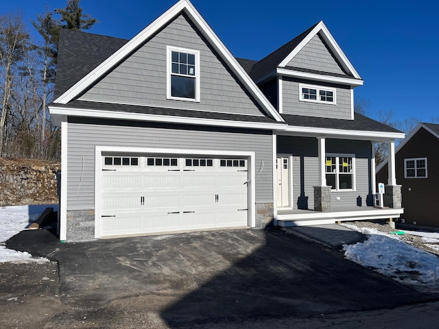 craftsman inspired home featuring a garage and a porch