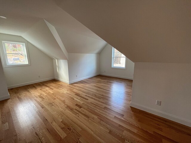 additional living space featuring light hardwood / wood-style flooring and vaulted ceiling