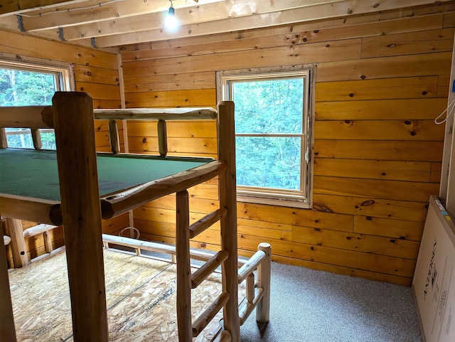 unfurnished bedroom featuring carpet flooring and wooden walls