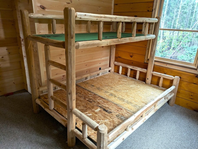 bedroom featuring carpet flooring and wooden walls