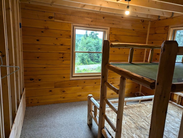 carpeted bedroom with wood walls