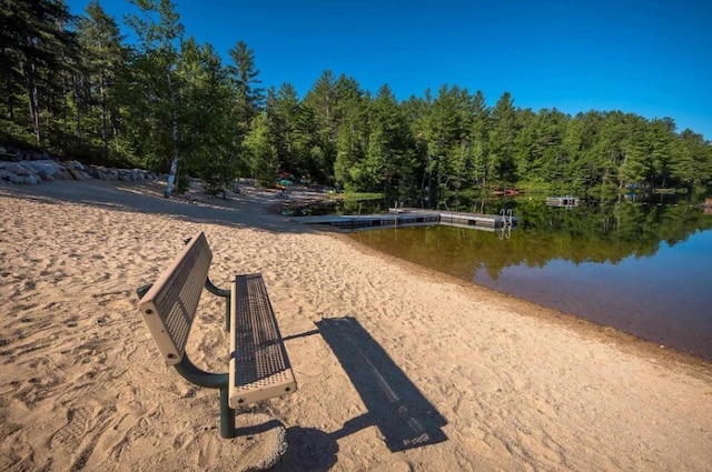 view of home's community with a water view and a wooded view