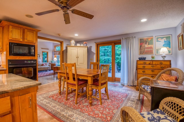 dining space with light tile patterned flooring, ceiling fan, and a textured ceiling