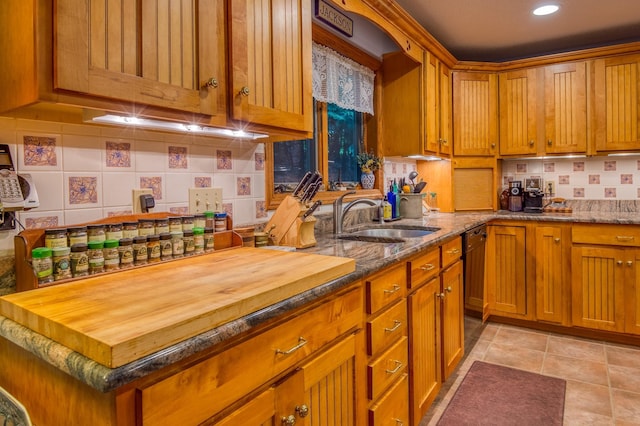 kitchen featuring light tile patterned flooring, tasteful backsplash, dishwasher, sink, and light stone countertops