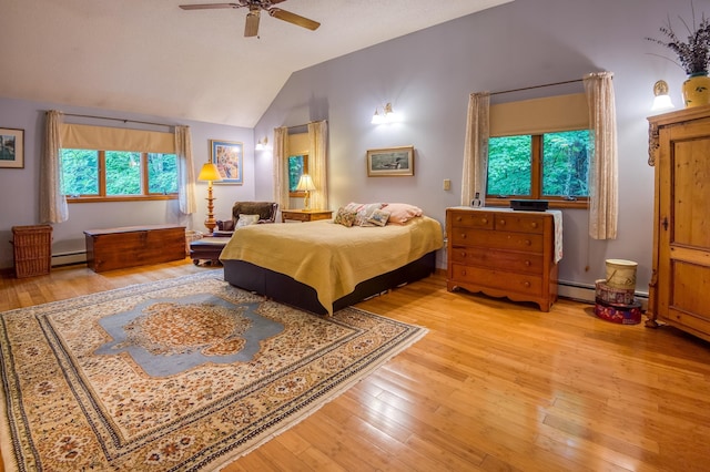 bedroom with ceiling fan, lofted ceiling, light hardwood / wood-style floors, and a baseboard heating unit