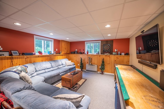 carpeted living room featuring a drop ceiling and a wealth of natural light