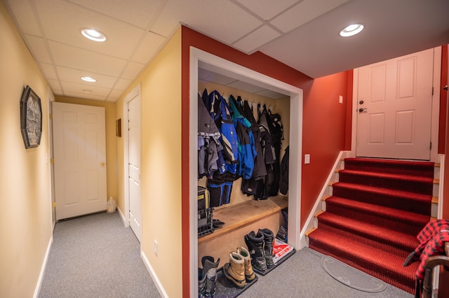 hallway featuring a drop ceiling and light colored carpet