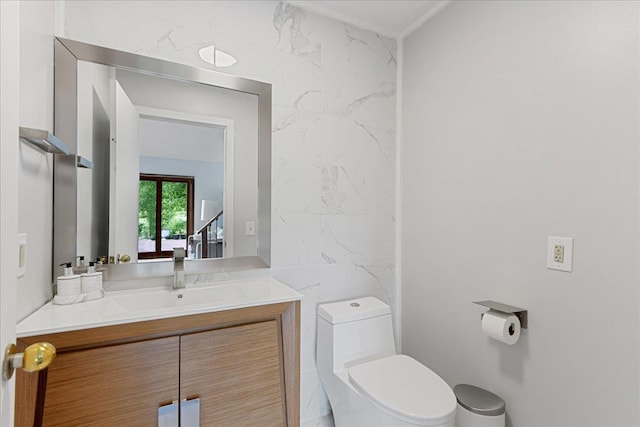 bathroom with tile walls, toilet, and vanity