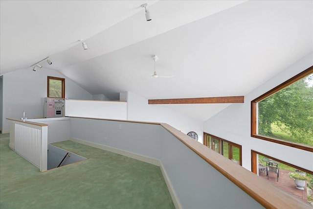 interior space with ceiling fan, carpet flooring, and vaulted ceiling with beams