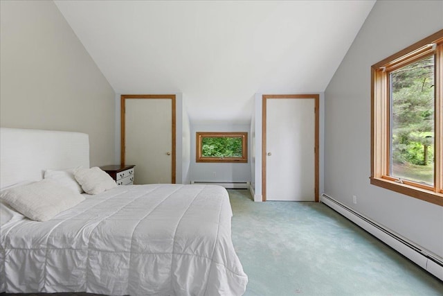 bedroom with a baseboard heating unit, vaulted ceiling, and carpet flooring