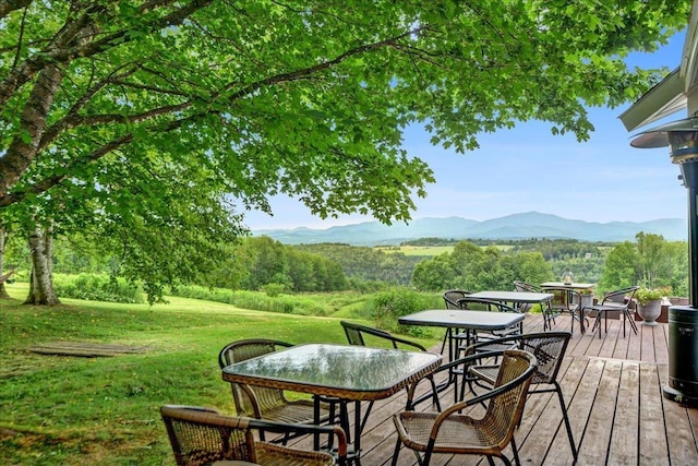 wooden terrace with a mountain view and a yard