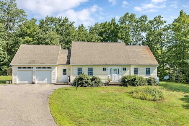 cape cod house featuring a front yard, roof with shingles, driveway, and an attached garage