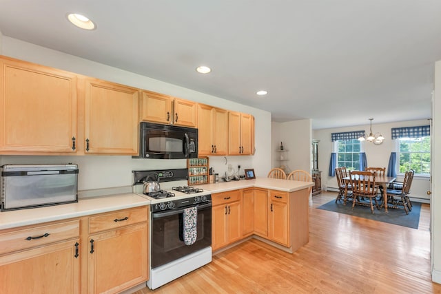 kitchen with black microwave, light brown cabinets, a peninsula, light countertops, and gas stove