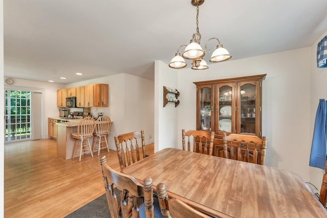 dining room with light wood-style floors, a notable chandelier, and recessed lighting