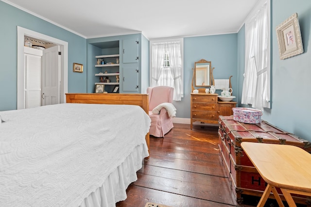 bedroom featuring crown molding and dark wood-type flooring