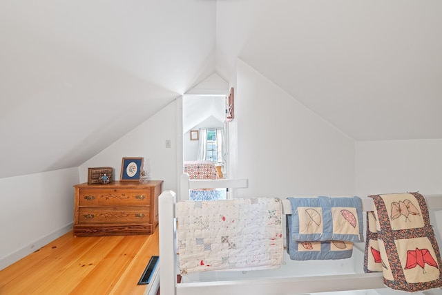 bedroom with hardwood / wood-style flooring and vaulted ceiling