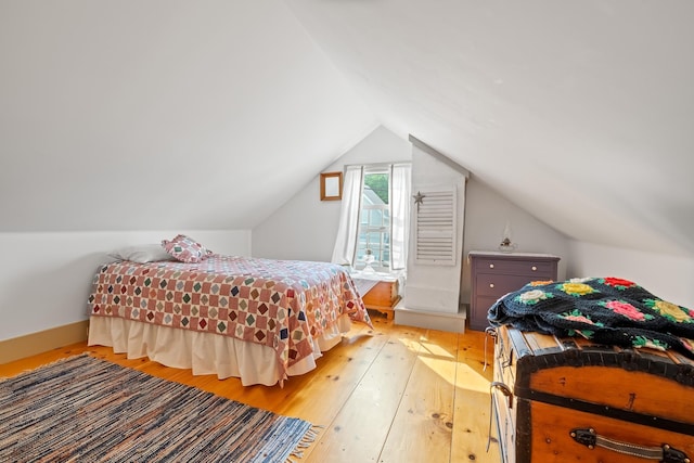 bedroom with hardwood / wood-style flooring and lofted ceiling