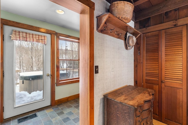 mudroom featuring visible vents, tile walls, and baseboards