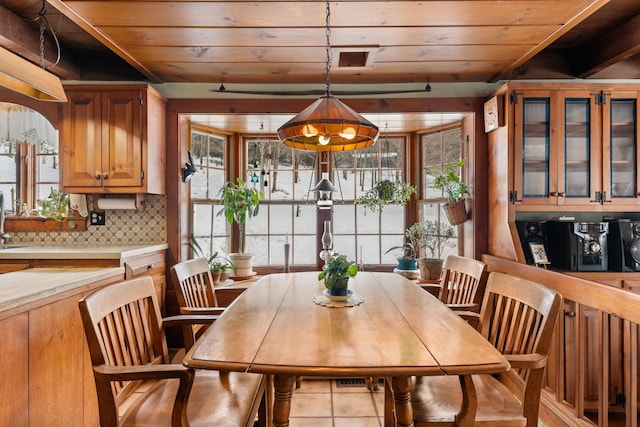 tiled dining area featuring a healthy amount of sunlight and wooden ceiling