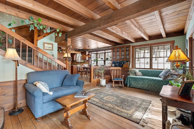 living room featuring beam ceiling, stairway, wainscoting, wooden ceiling, and hardwood / wood-style flooring