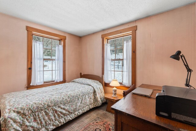 bedroom with a textured ceiling and wallpapered walls