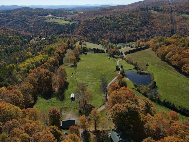 drone / aerial view with a forest view and a water view