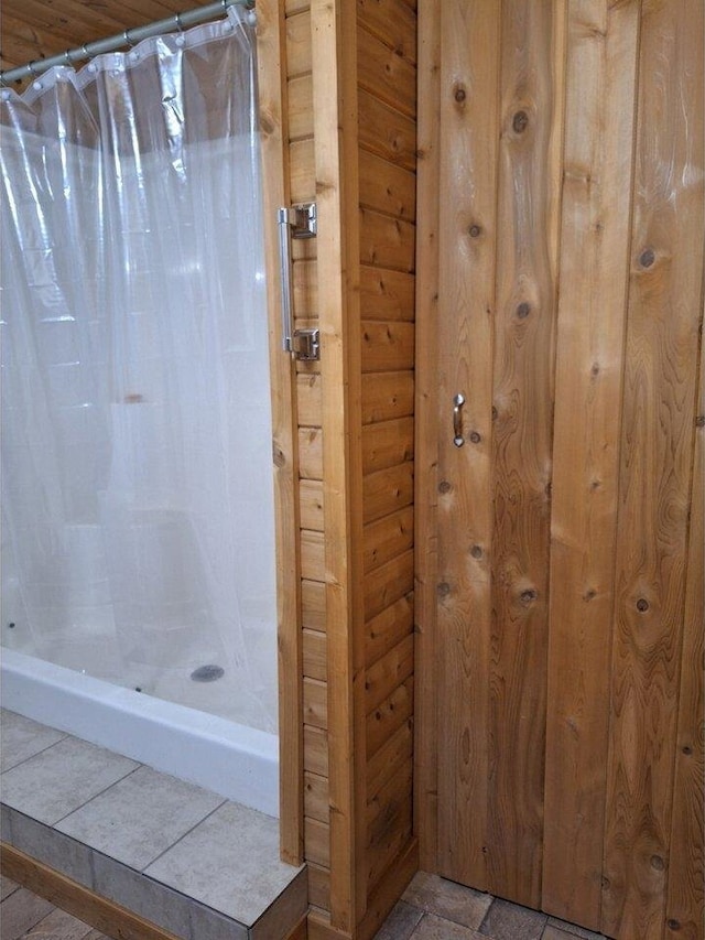 bathroom featuring wooden walls and tile patterned flooring