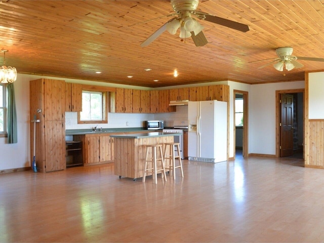 kitchen featuring wood ceiling, white appliances, a breakfast bar, a kitchen island, and decorative light fixtures