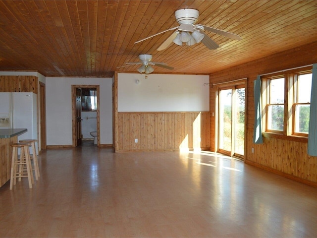 unfurnished living room featuring ceiling fan and wood ceiling