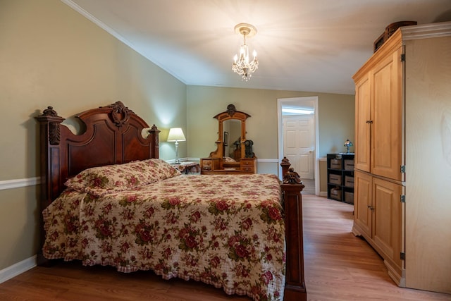 bedroom with light wood-style flooring, baseboards, a chandelier, and ornamental molding
