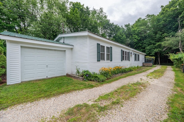 view of front of house with an attached garage, driveway, and metal roof