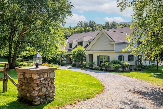 view of front of property with driveway, a shingled roof, and a front yard