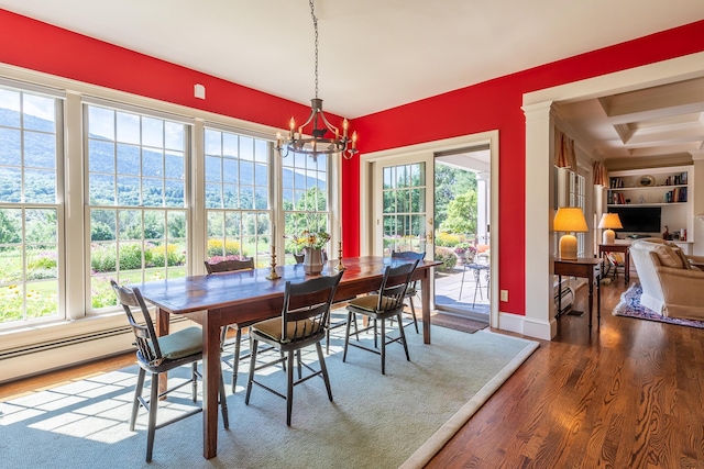 dining room featuring a wealth of natural light, baseboards, wood finished floors, and an inviting chandelier