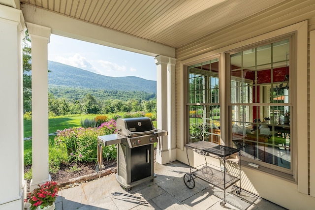 view of patio featuring a porch, area for grilling, and a mountain view