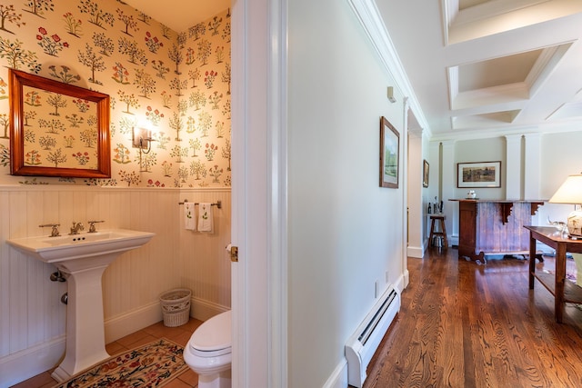 bathroom with crown molding, a baseboard heating unit, wainscoting, wood finished floors, and wallpapered walls