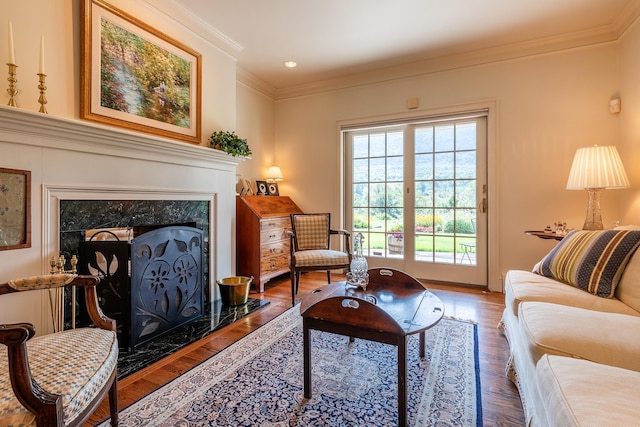 living area with ornamental molding, wood finished floors, and a premium fireplace