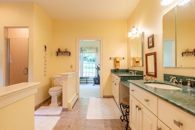 full bathroom featuring toilet, a sink, baseboards, baseboard heating, and a stall shower