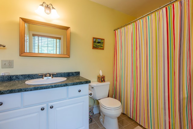 bathroom with a shower with curtain, vanity, toilet, and tile patterned floors