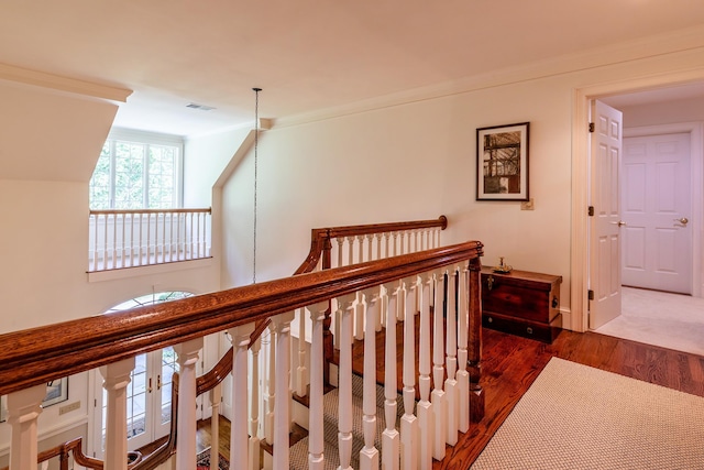 hall featuring ornamental molding, visible vents, dark wood finished floors, and an upstairs landing