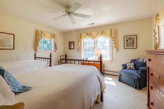 bedroom with a baseboard heating unit, multiple windows, visible vents, and light colored carpet