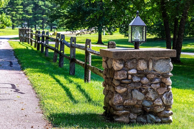 view of home's community featuring fence and a lawn