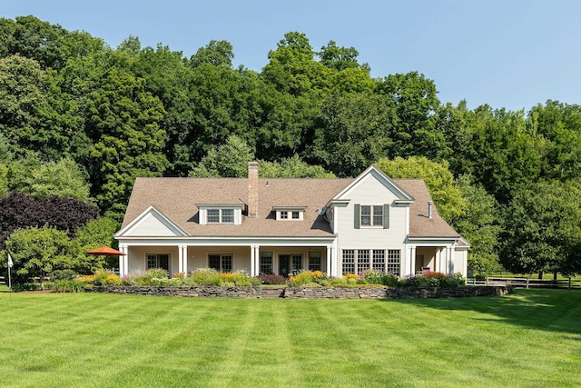 view of front facade featuring a chimney and a front yard