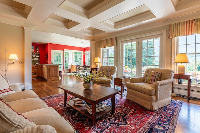 living area featuring a baseboard heating unit, coffered ceiling, wood finished floors, and ornamental molding