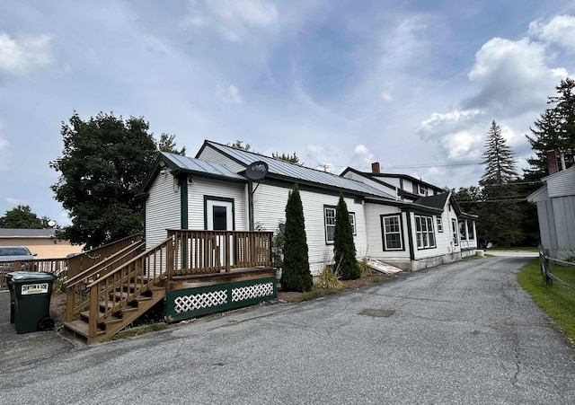 view of front of house with metal roof and a chimney