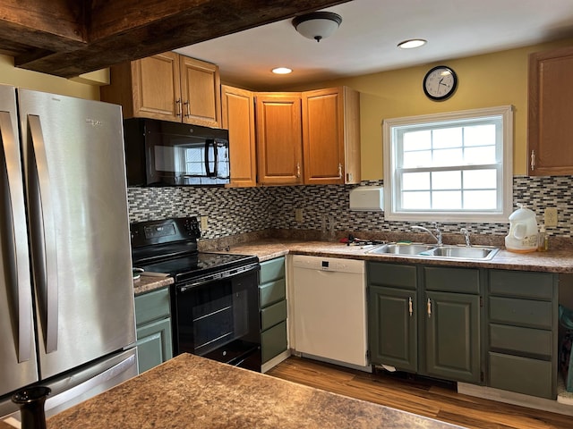 kitchen with black appliances, a sink, backsplash, wood finished floors, and recessed lighting