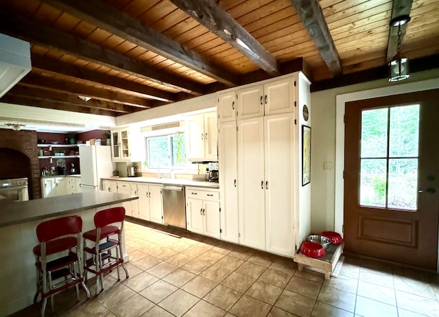 kitchen with beamed ceiling, stainless steel dishwasher, wooden ceiling, and light tile patterned floors